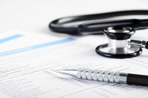 Stethoscope and pen resting on medical documents, ready for examination.